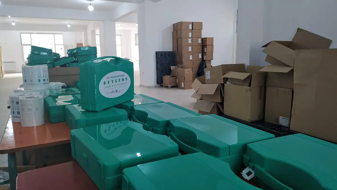 Boîtes de kit respiratoire oxygène empilées dans entrepôt.