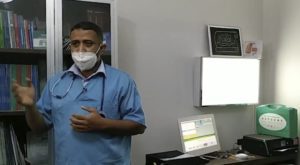 Médecin avec masque dans un cabinet médical moderne.